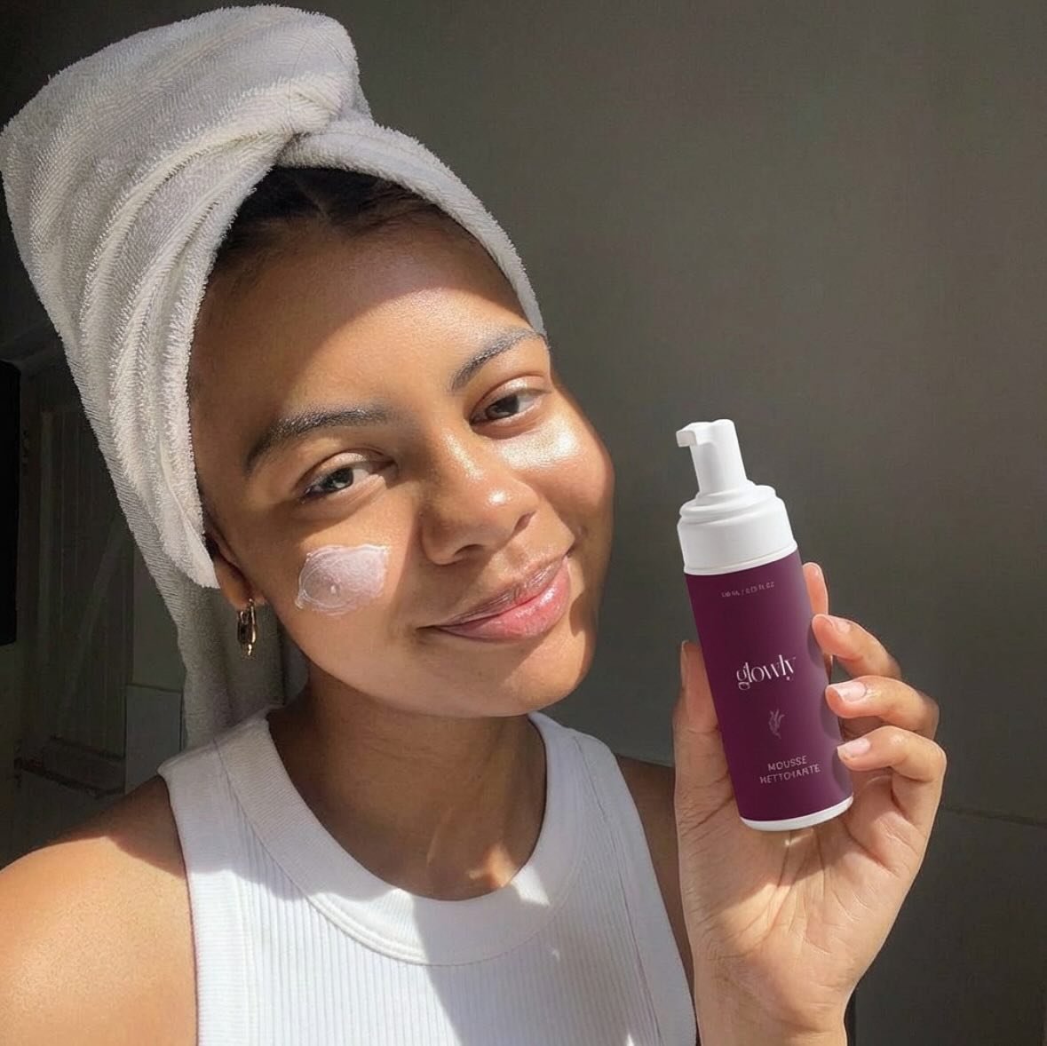 Femme tenant la mousse nettoyante Luméa